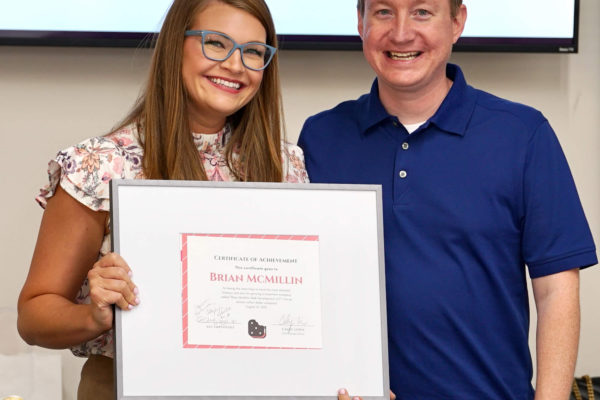 Brian, Neapolitan Labs president, receives an award from Caley, chief business officer