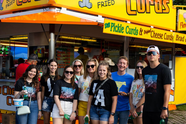 Neapolitan Labs team members standing in front of a cheese curds booth at the Iowa State Fair.