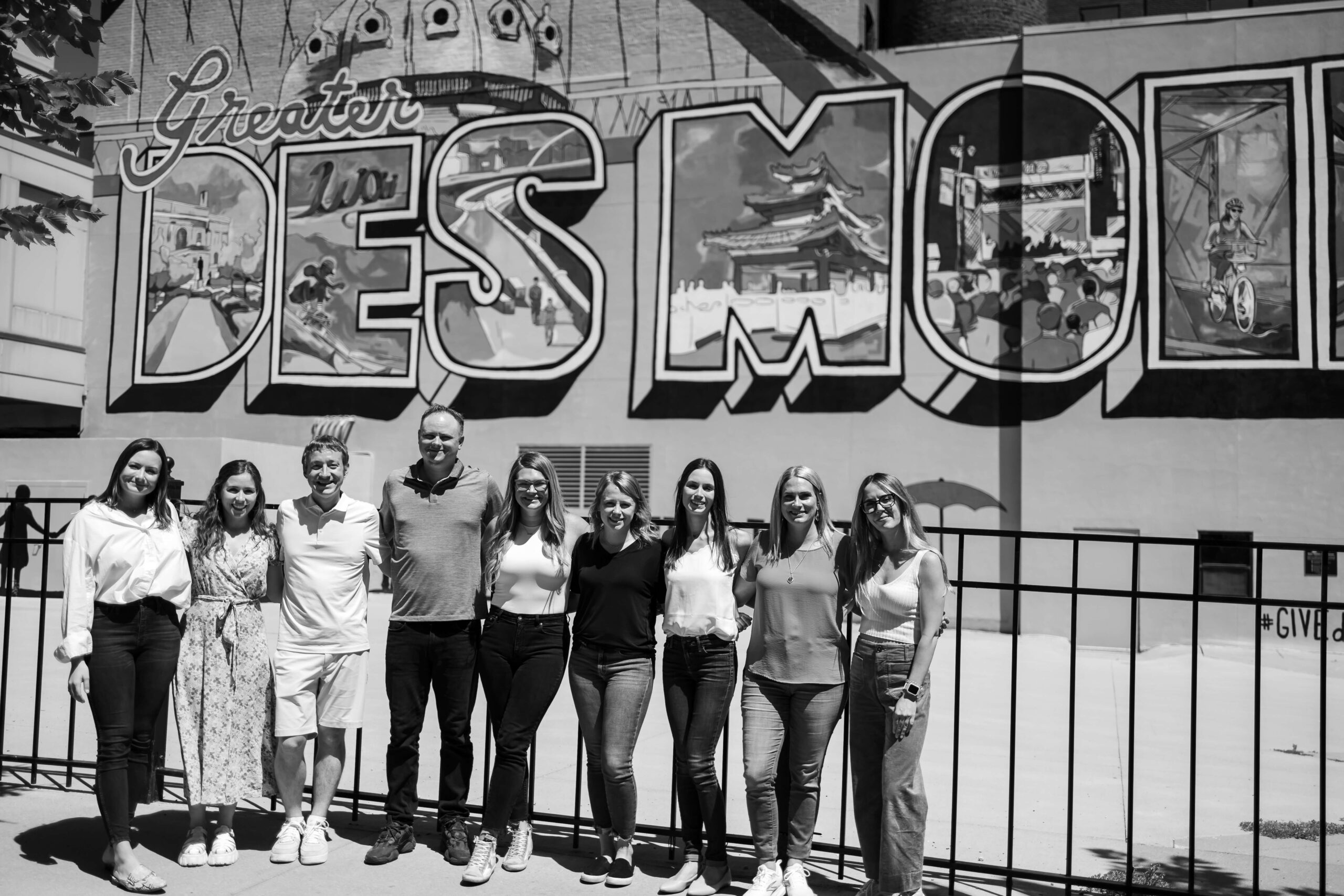 Neapolitan Labs team members standing in front of "Des Moines" mural.