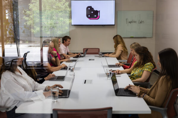 Neapolitan Labs team members gather around a long board table for their annual business meeting.